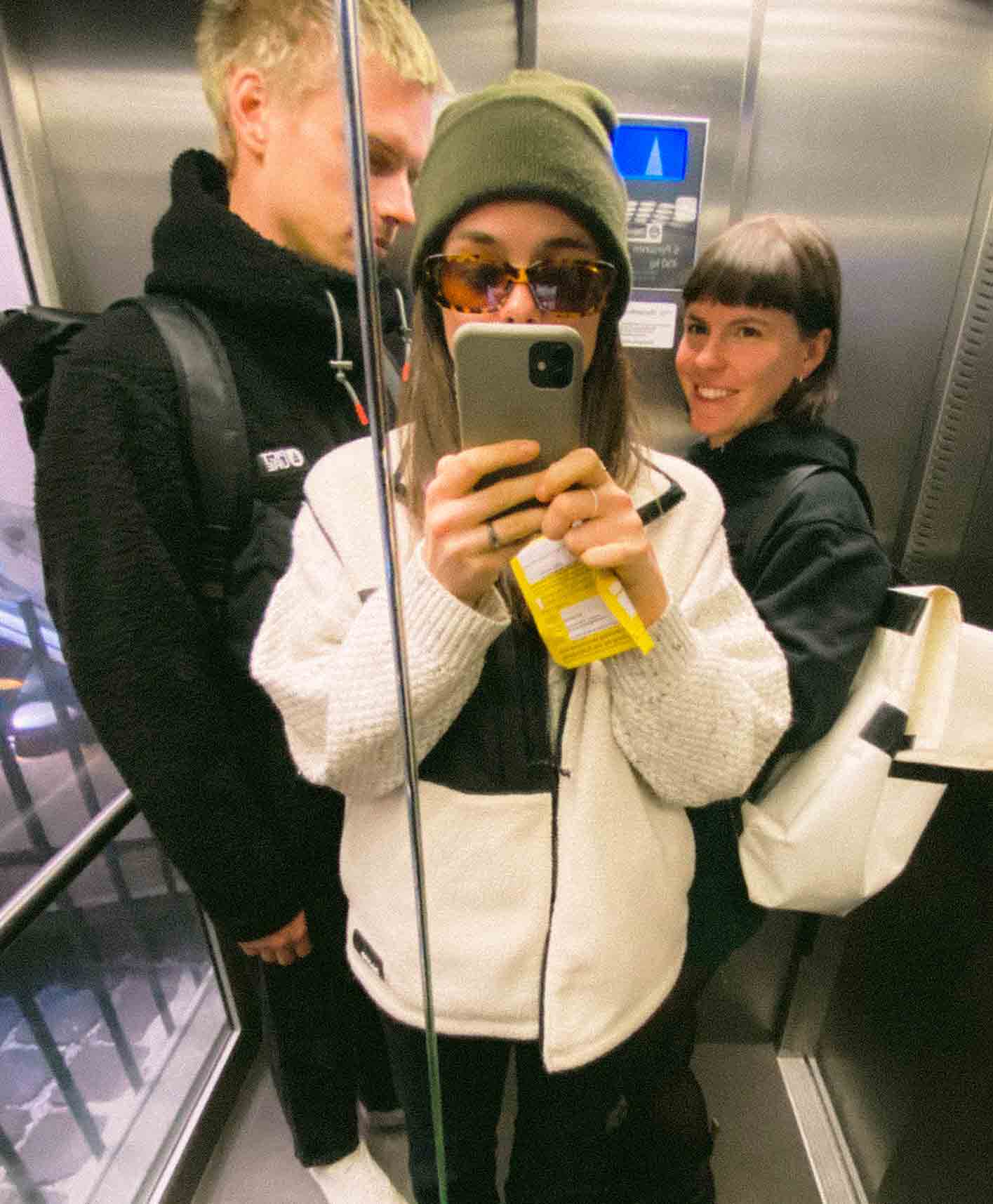 A selfie of the three co-founders of RAWTY in fish-eye style standing in an elevator next to each other wearing outdoor clothes.