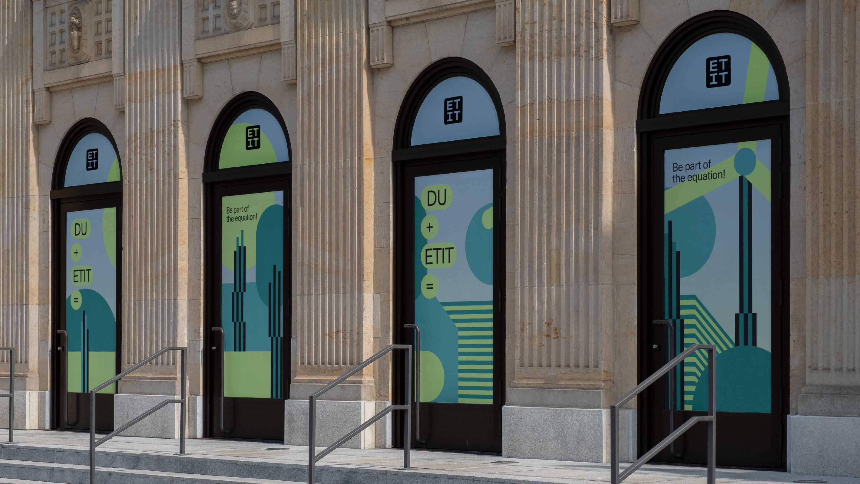 A photo of an entrance of a university building with window signage of illustrations and slogans of the ETIT TU Vienna campaign concept in bright blue and neon green-yellow colors.
