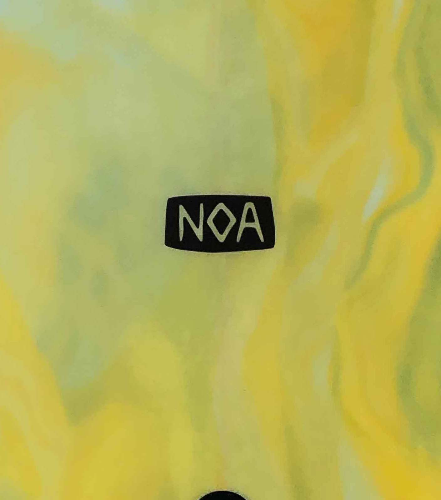 The NOA Surfboards logo on a green and yellow surfboards that has a flowing organic texture.